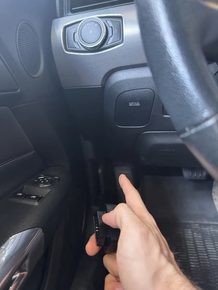 La prise OBD2 sous le volant, où le traceur se branche